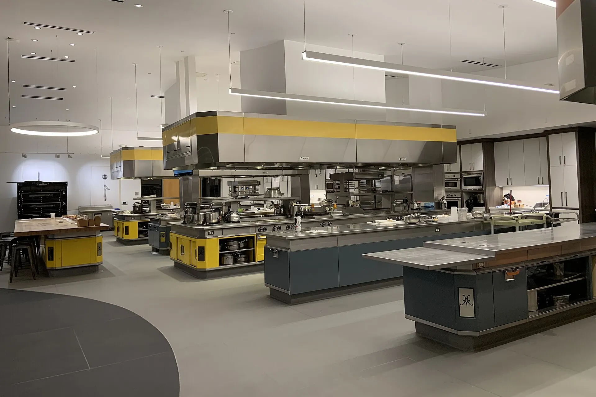 Clean commercial kitchen with stainless steel cooking stations and prep islands