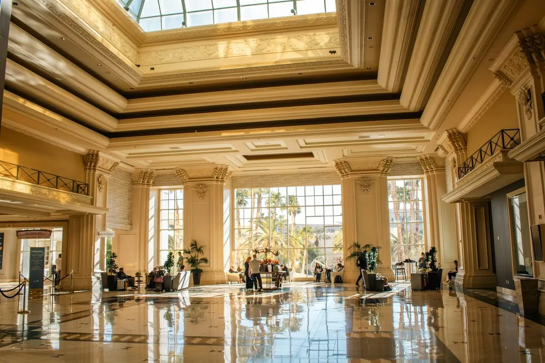 Hotel lobby with a polished floor, tall columns and a skylight