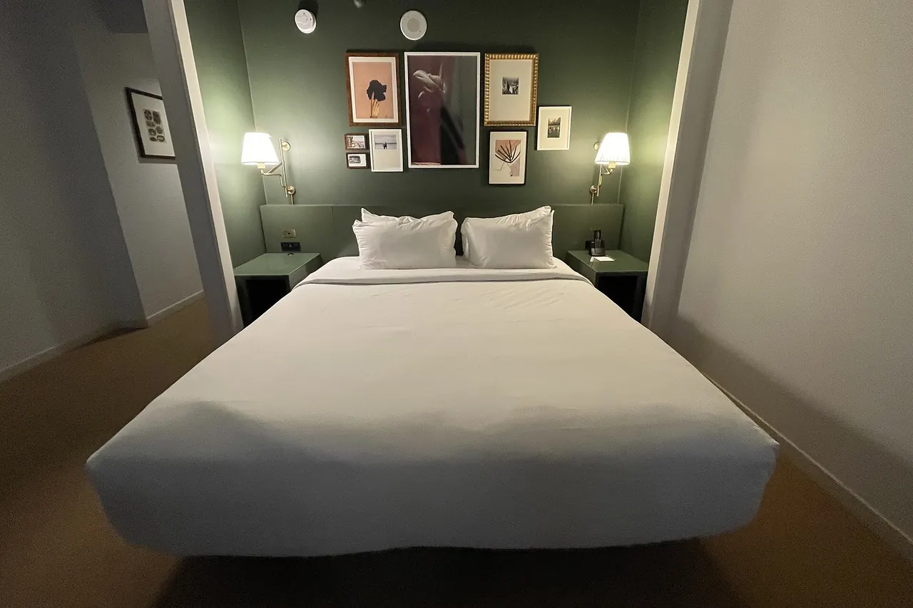 Freshly made bed with white linens in a hotel room